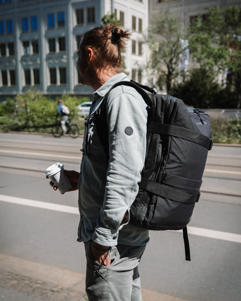 Mann trägt den NQ1 Rucksack mit 24 Litern in der Stadt